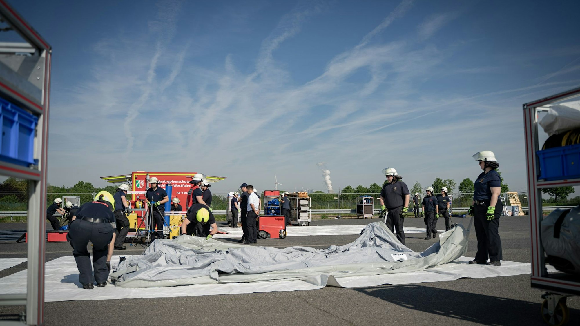 Feuerwehrleute bauen den Dekontaminationsplatz auf.