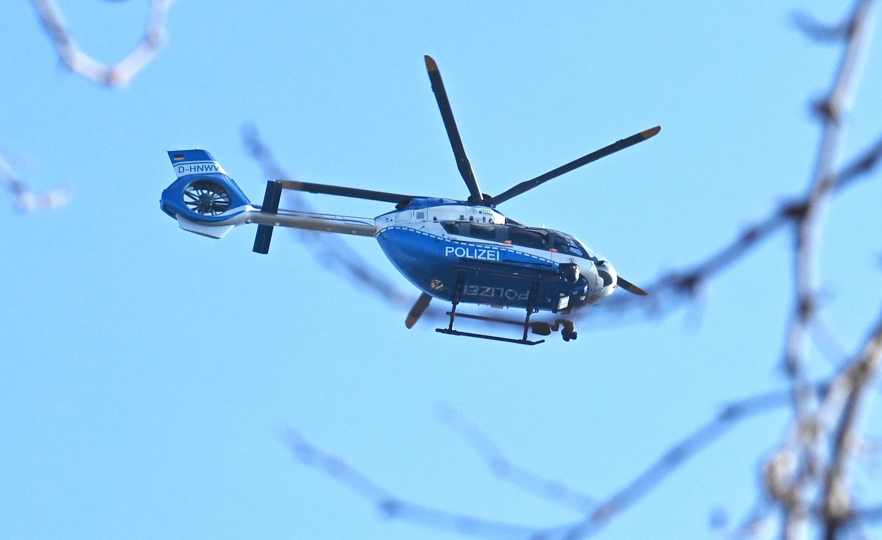 Ein Polizeihubschrauber kreist in der Luft.