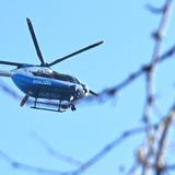 Ein Polizeihubschrauber kreist in der Luft.