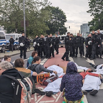 Aktivisten der „Letzten Generation“ blockieren am Mittwoch die Augustinerstraße in der Kölner Altstadt, unweit des Heumarkts.
