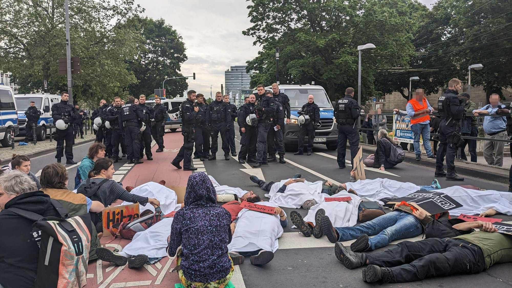 Aktivisten der „Letzten Generation“ blockieren am Mittwoch die Augustinerstraße in der Kölner Altstadt, unweit des Heumarkts.