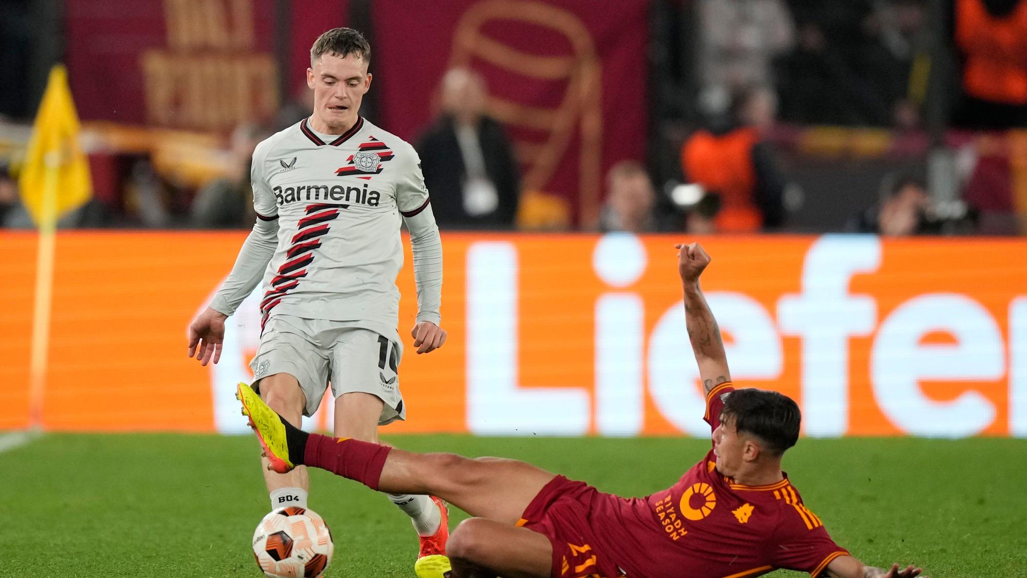 Leverkusens Florian Wirtz (l) und Roms Paulo Dybala kämpfen um den Ball.