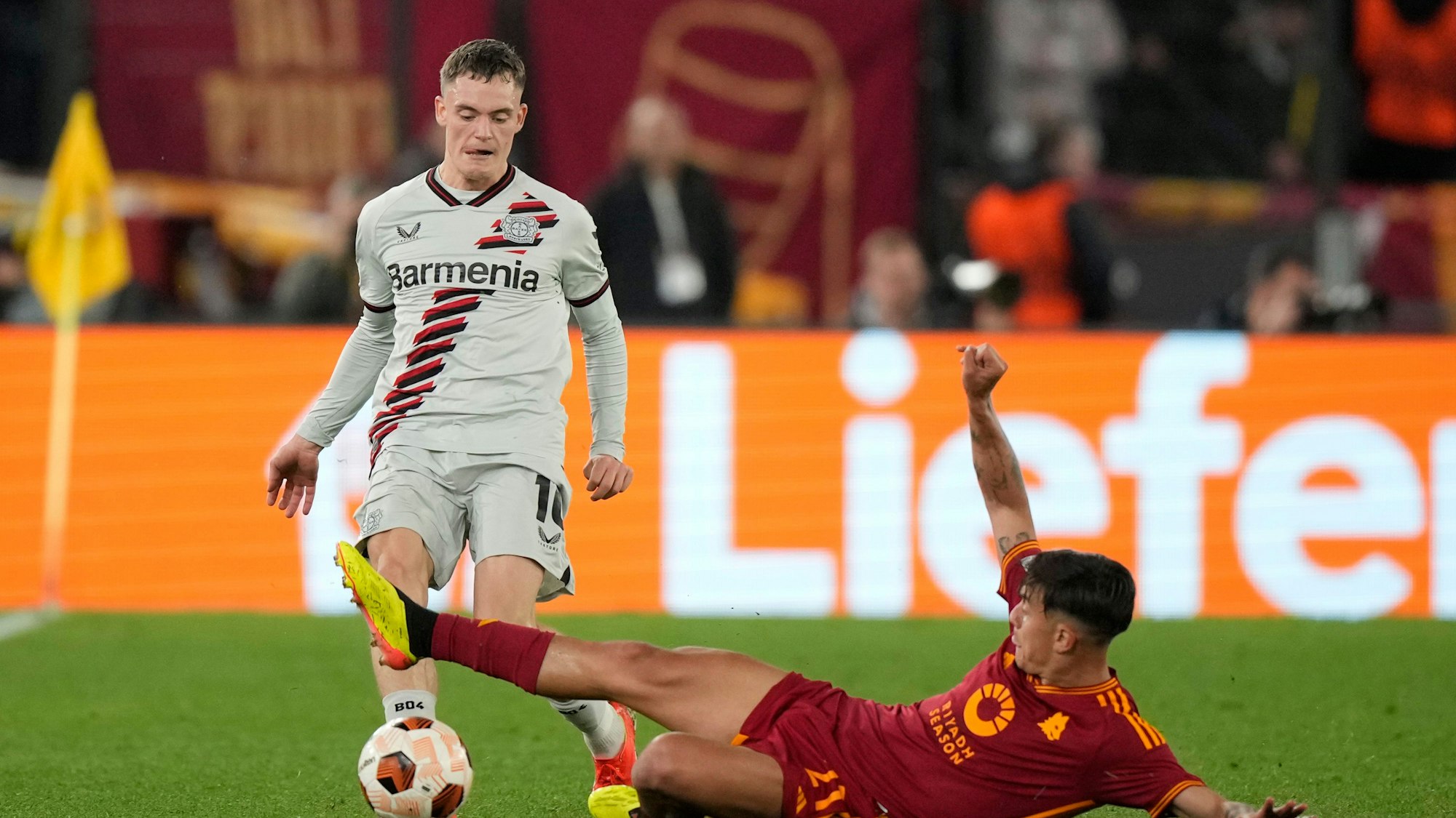 Leverkusens Florian Wirtz (l) und Roms Paulo Dybala kämpfen um den Ball.