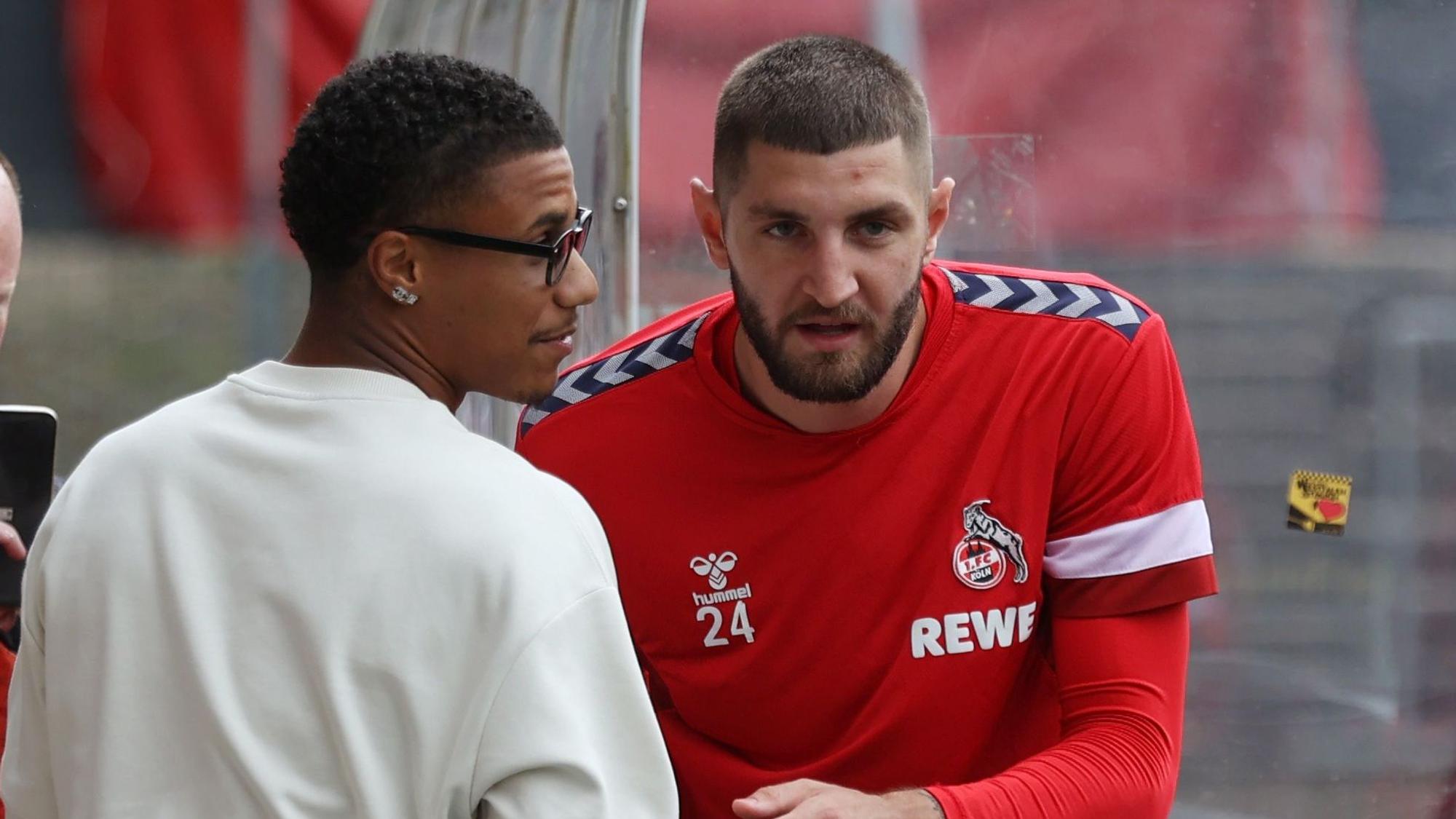 Ismail Jakobs wechselt nach der Einheit ein paar Worte mit Kölns Verteidiger Jeff Chabot (r.)