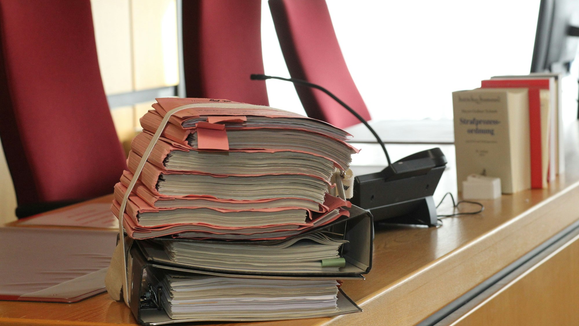 Auf einem Richtertisch im Amtsgericht Siegburg liegt ein Aktenstapel.