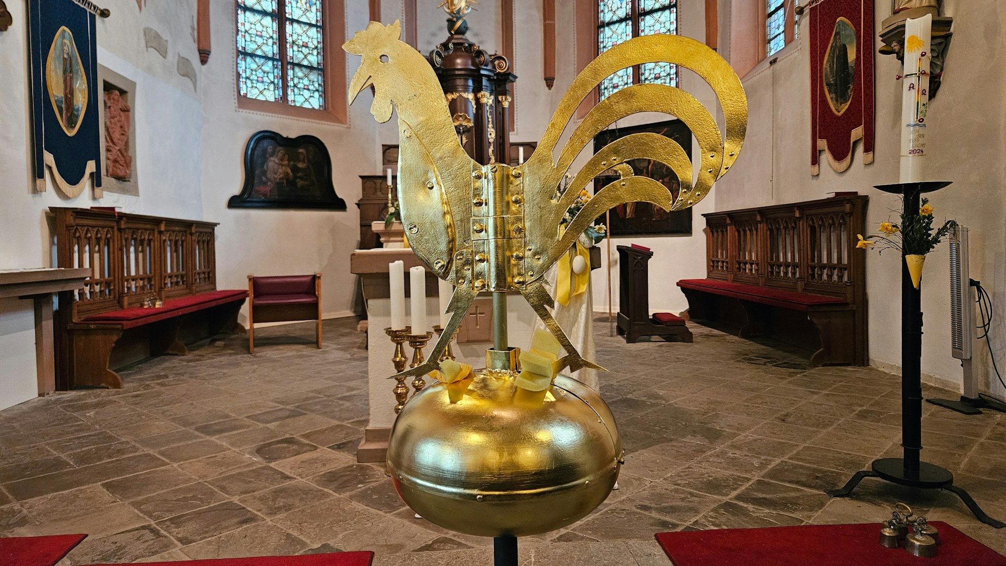 Der goldene Hahn steht im Innenraum der Kirche.