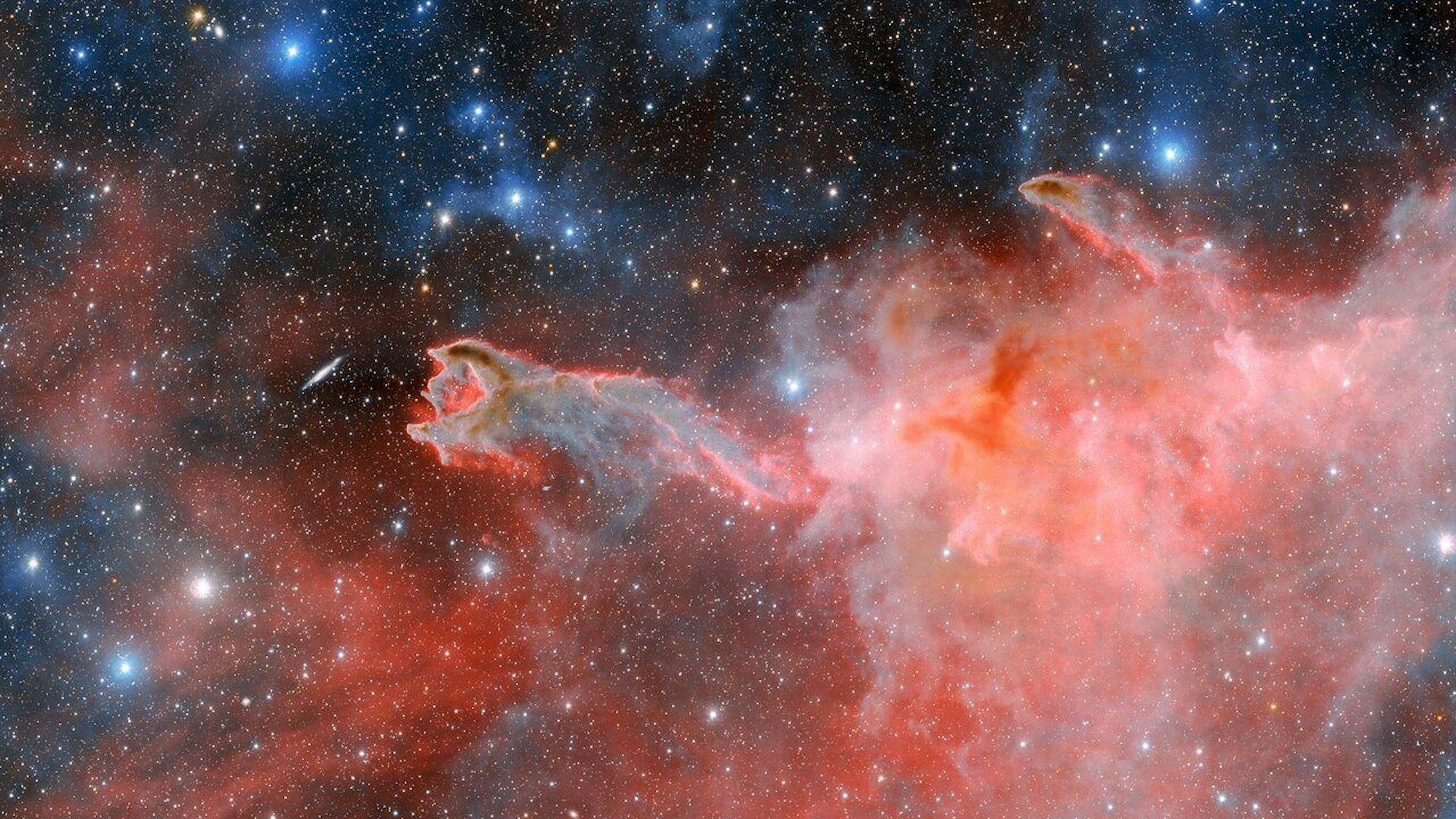 Man sieht ein Bild aus dem Weltall, auf dem ein roter Sternennebel, welcher wie eine Hand aussieht, nach einer vor ihm liegenden Galaxie zu greifen scheint.