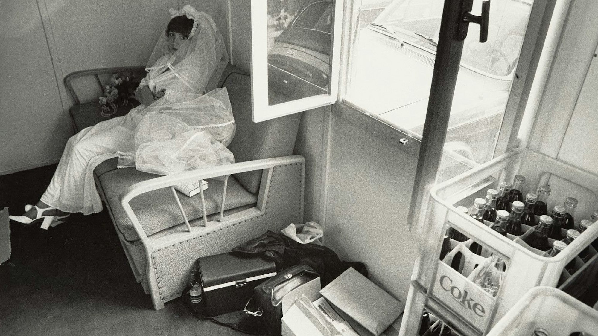 Eine Braut sitzt der Abstellkammer eine Kneipe mit Getränkekisten.