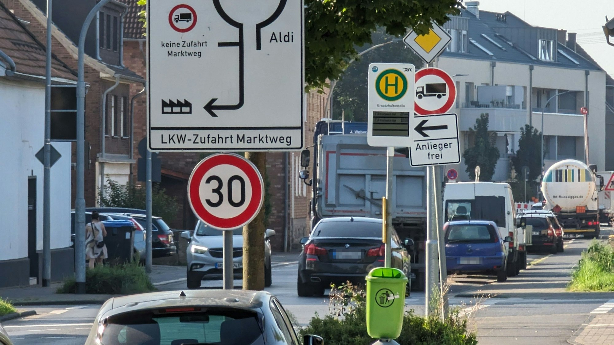 Eine stark befahrene Straße mit einem Schilderwald am Straßenrand.