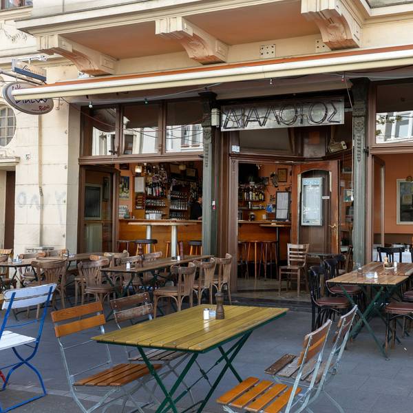 Das Restaurant „Dialog“ mit Holztischen- und Stühlen vor der Tür und innen.
