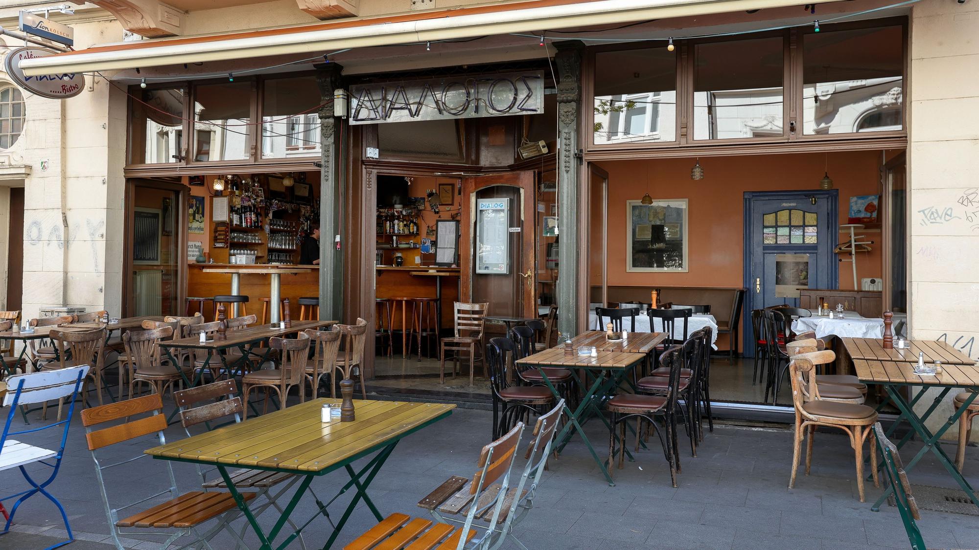 Das Restaurant „Dialog“ mit Holztischen- und Stühlen vor der Tür und innen.
