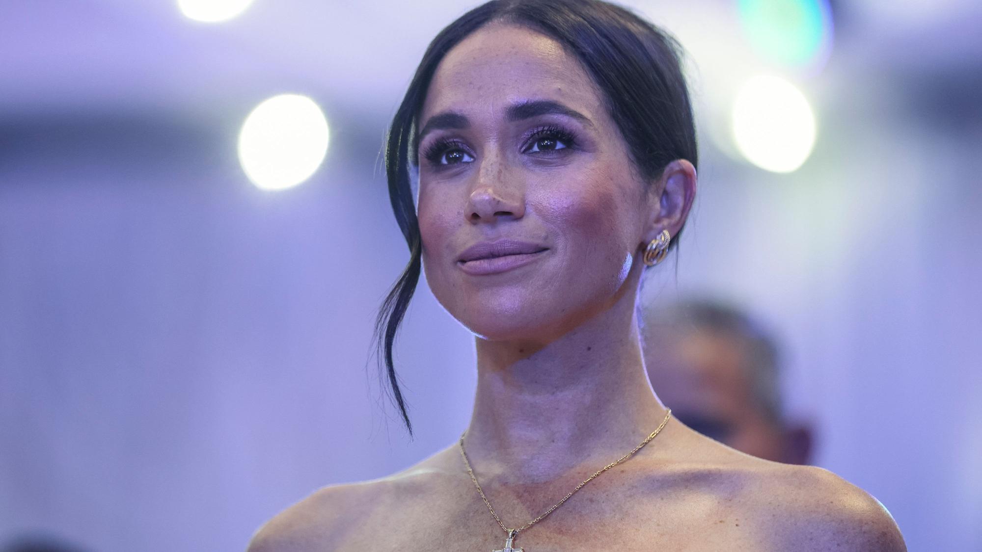 Meghan Markle schaut bei einer Rede von Prinz Harry zu.