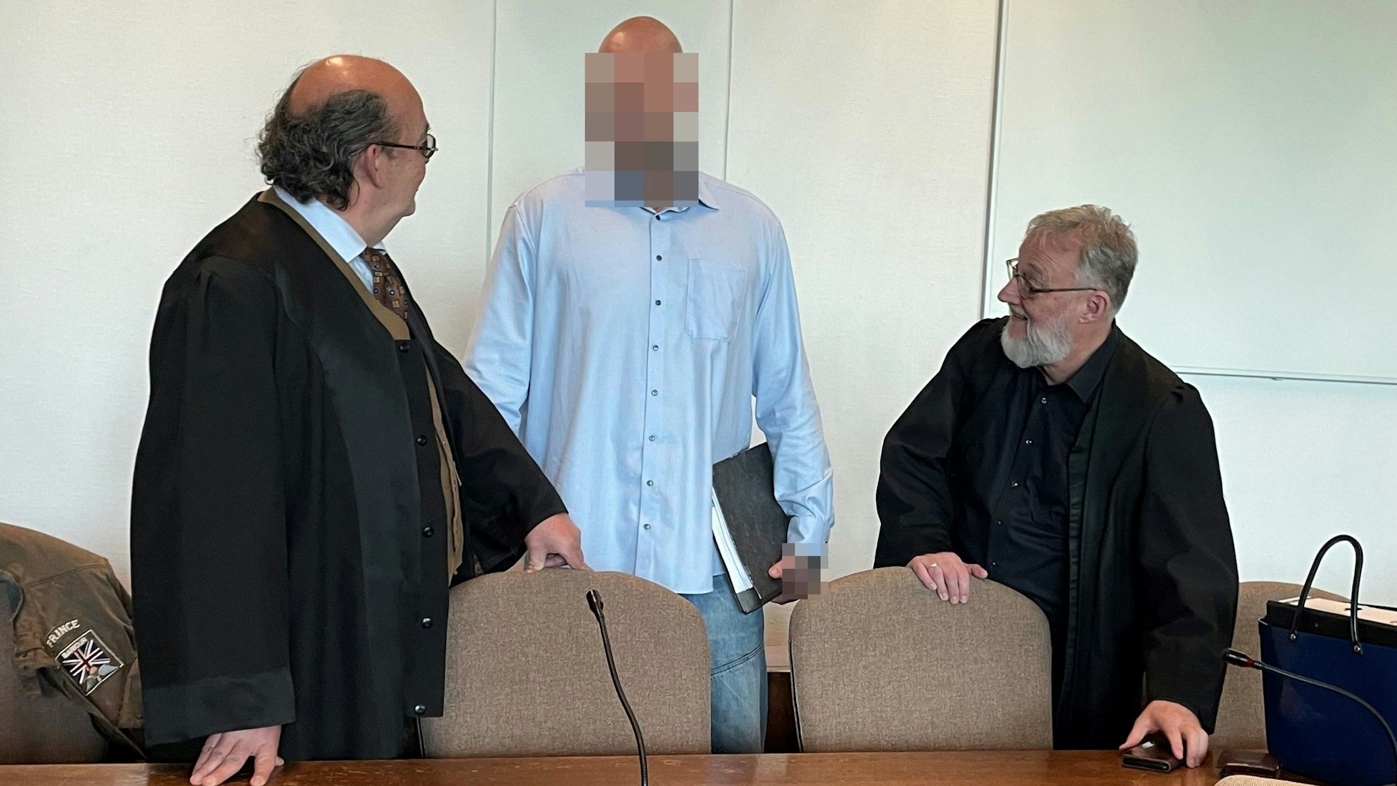 Einer der Angeklagten mit den Verteidigern Uwe Krechel und Thomas Ohm beim Prozessauftakt im Kölner Landgericht