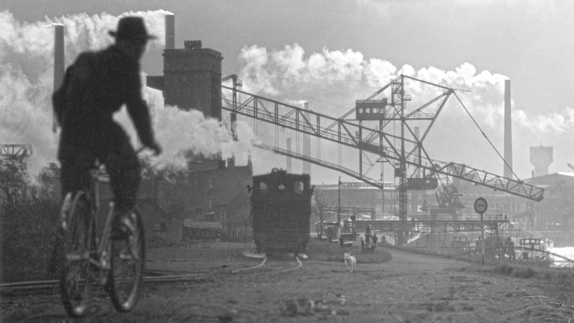 Ein Schwarz-Weiß-Bild zeigt das Rheinufer Leverkusen ca.1950, Bildmitte: Das sogenannte Kipp-Bähnchen, das zur Müllkippe fuhr.