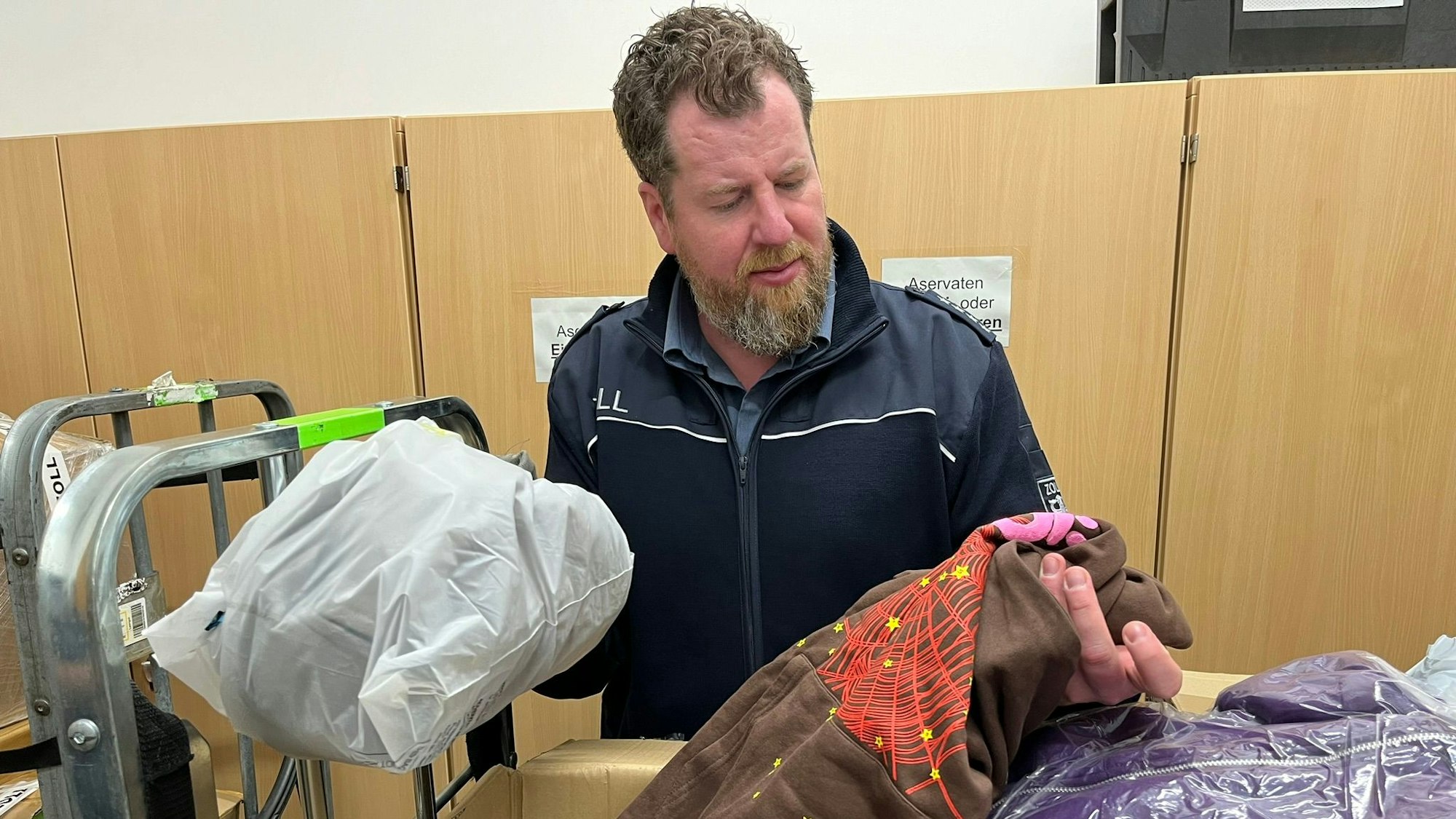 Jens Ahland, Pressesprecher des Hauptzollamts Köln, öffnet er ein Paket des chinesischen Versenders Pandabuy.