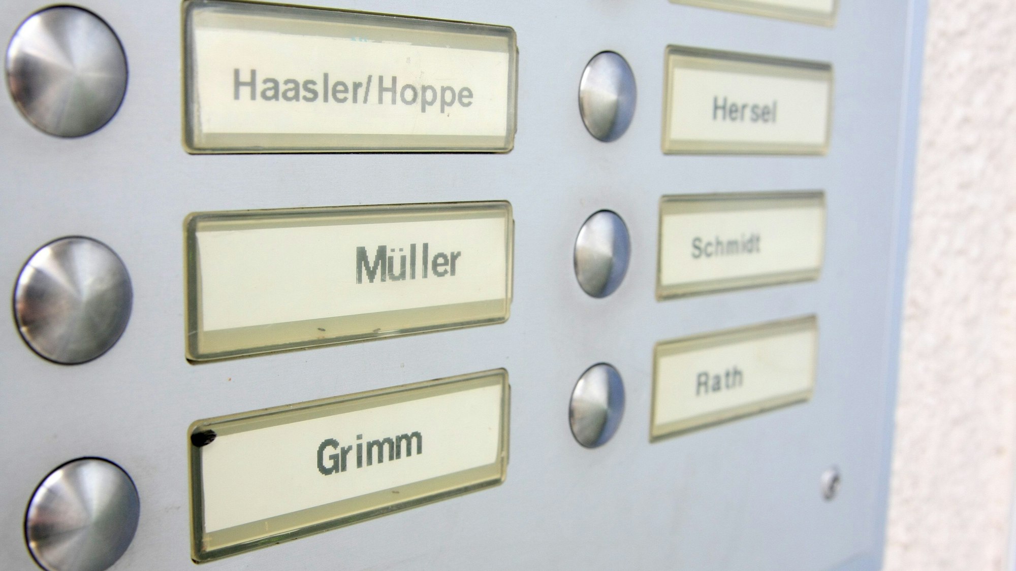 Auf einem Klingelschild in Berlin sind verschiedene Namen zu sehen. Zum Beispiel Müller, Grimm oder Schmidt,