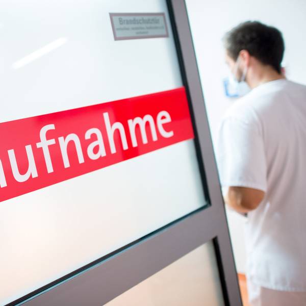 Ein Krankenpfleger tritt durch eine Glastür mit der Aufschrift "Notaufnahme".