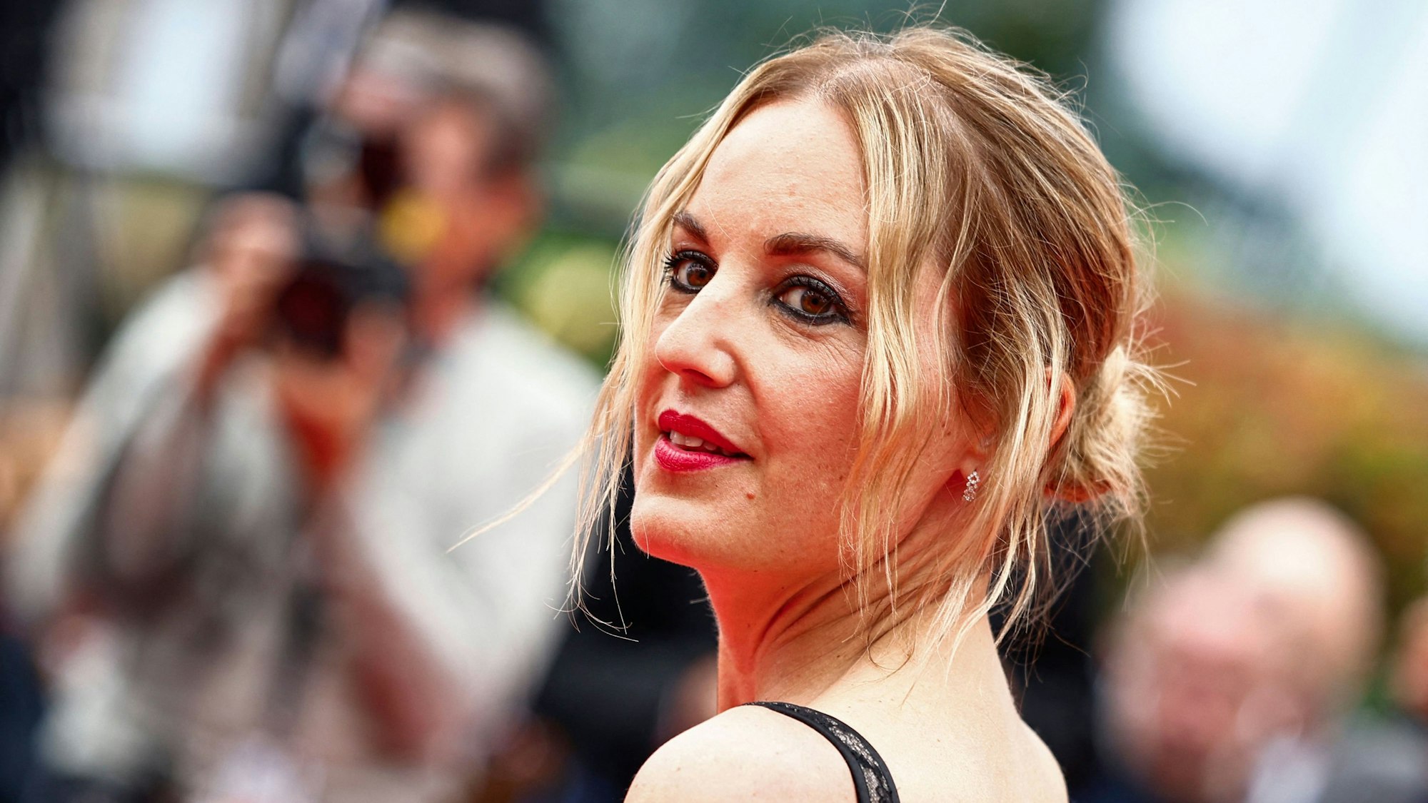 Agathe Riedinger steht vor Fotografen auf dem roten Teppich von Cannes.