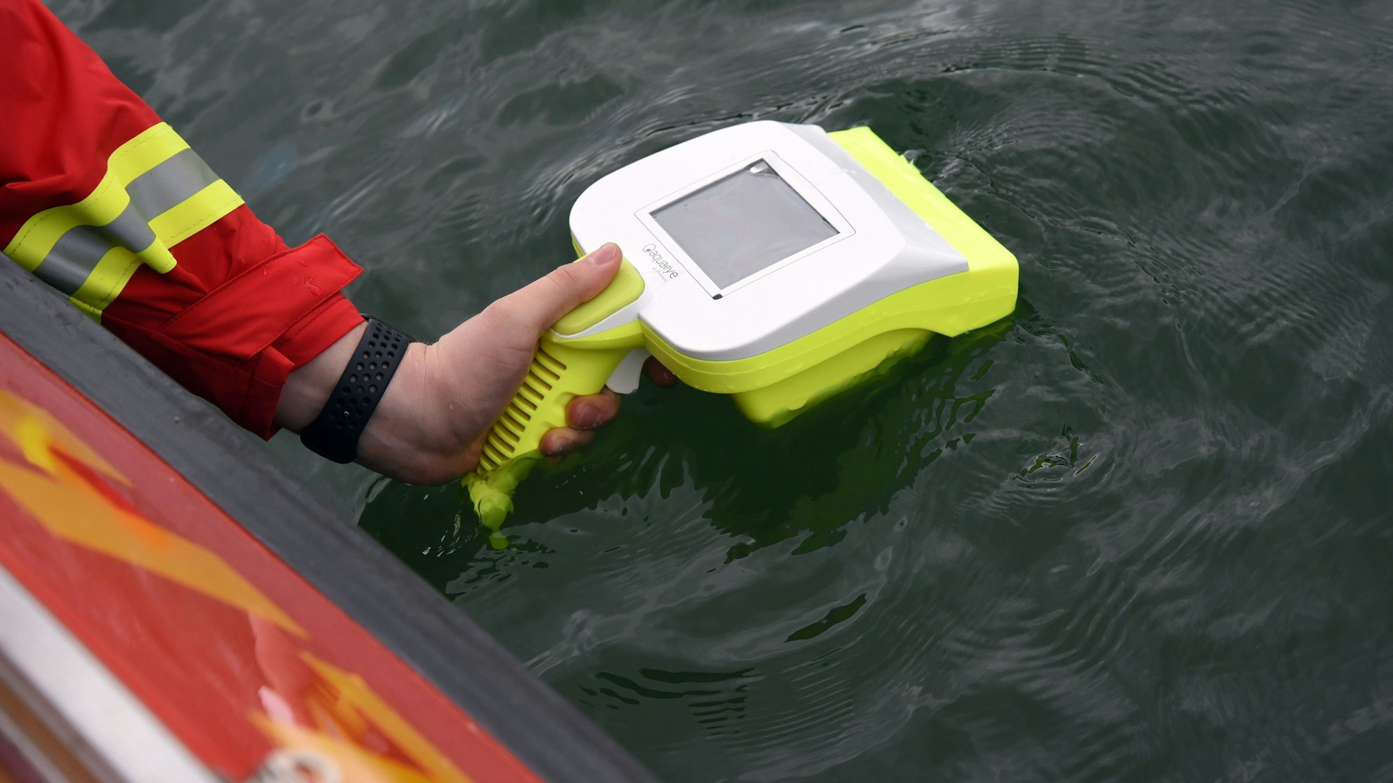 Ein Wasserretter hält ein Sonargerät über die Wasseroberfläche.