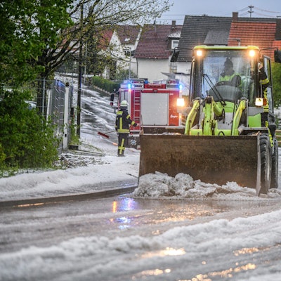 Einsatzkräfte der Feuerwehr räumen eine Straße in Baden-Württemberg. Wetterdienste warnen vor Dauerregen im Südwesten und Süden Deutschlands.