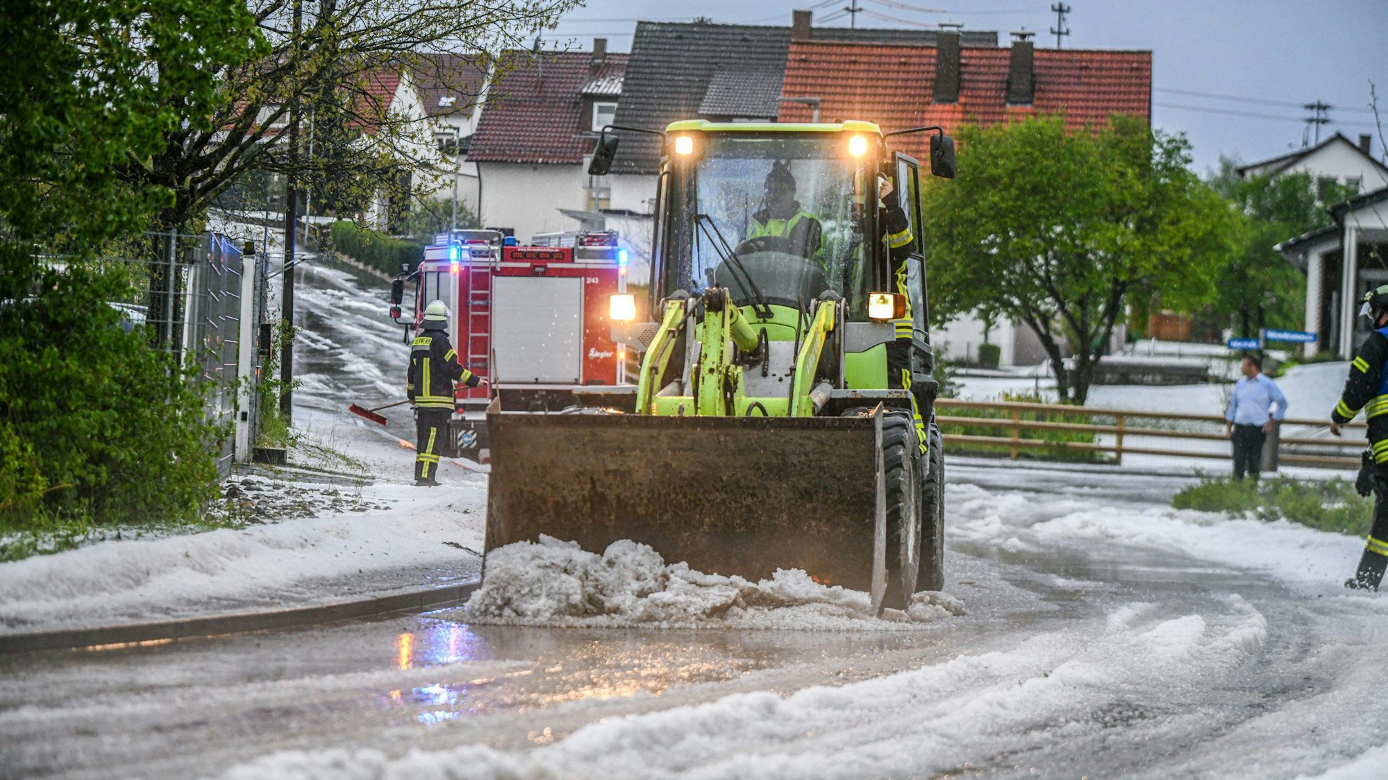 Einsatzkräfte der Feuerwehr räumen eine Straße in Baden-Württemberg. Wetterdienste warnen vor Dauerregen im Südwesten und Süden Deutschlands.