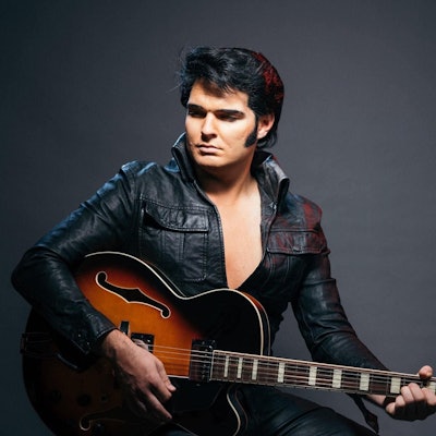 Ein Mann, der wie Elvis gekleidet ist, in Lederoutfit.