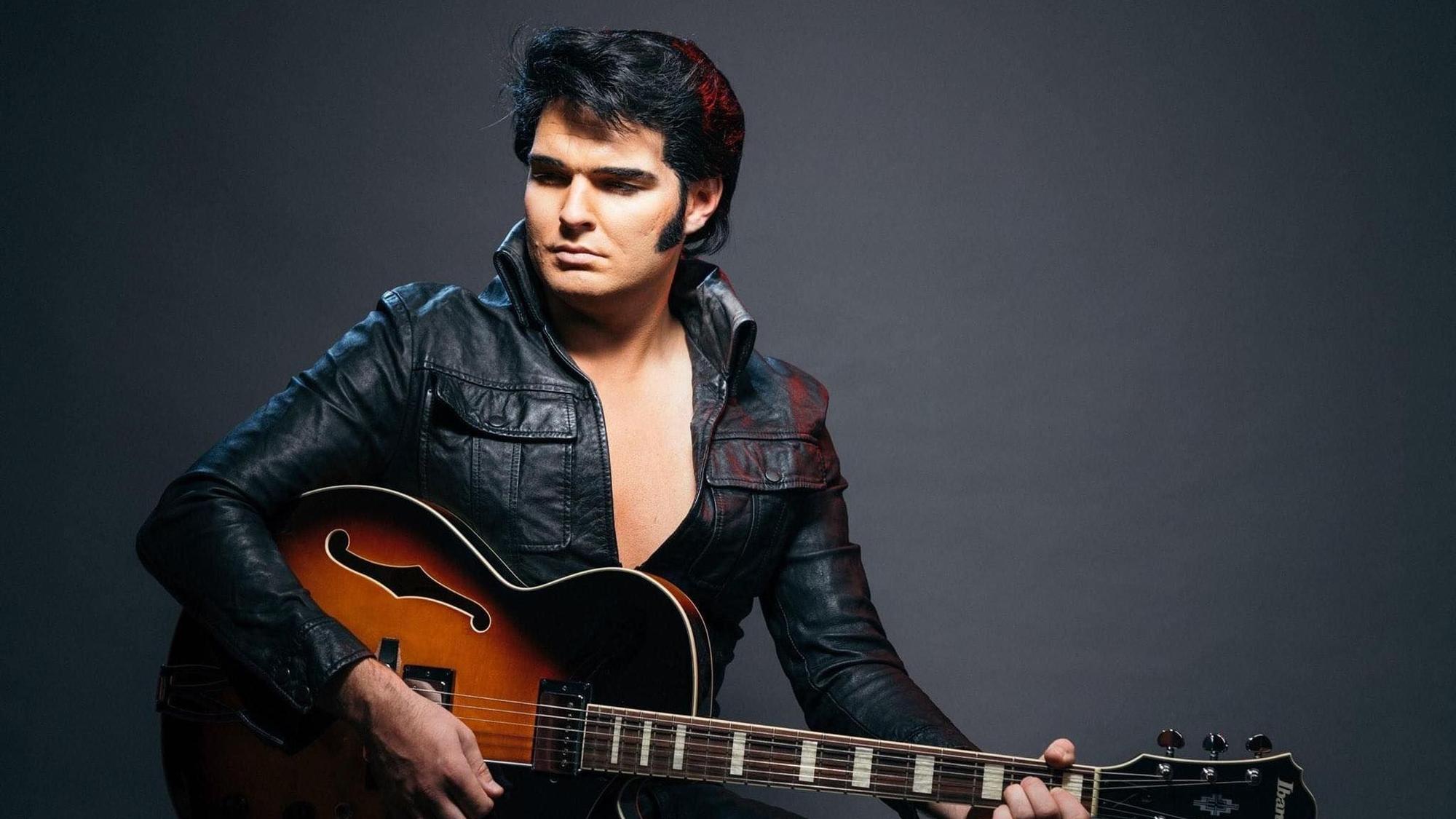 Ein Mann, der wie Elvis gekleidet ist, in Lederoutfit.