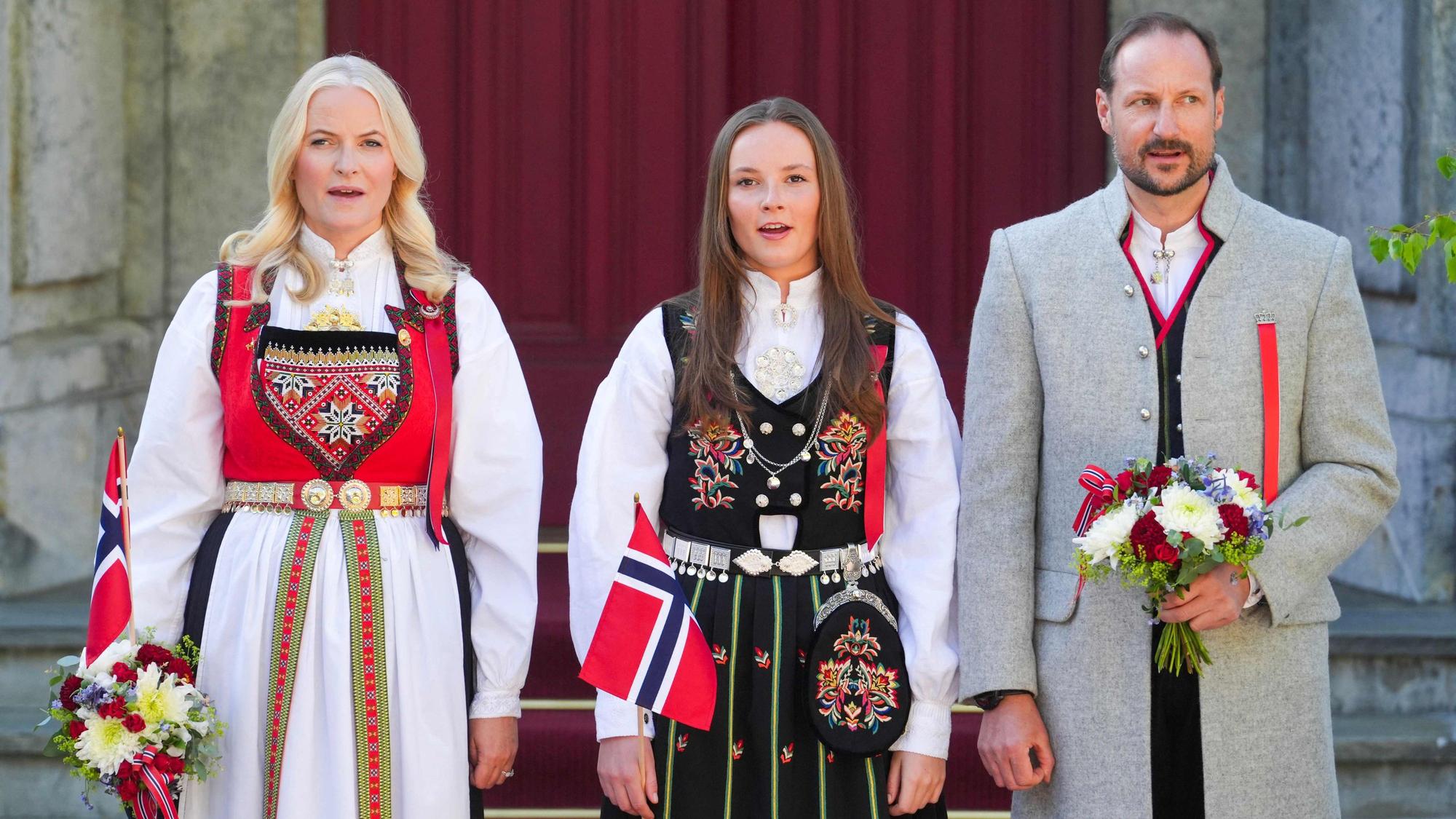 Am Nationalfeiertag 2024 singen Kronprinzessin Mette-Marit (links), Kronprinz Haakon-Magnus (rechts) und Prinzessin Ingrid Alexandra (Mitte) unter anderem die Nationalhymne.