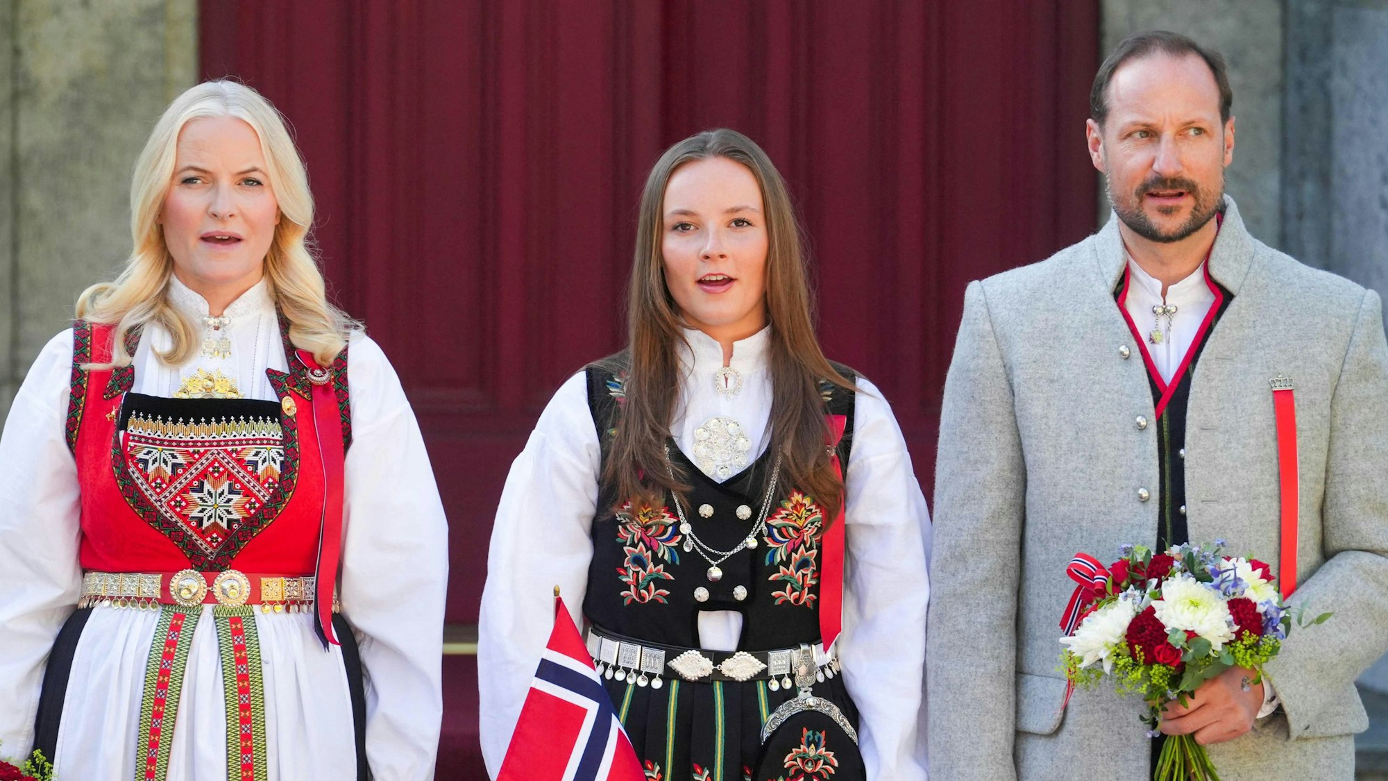 Kronprinzessin Mette-Marit (l), Kronprinz Haakon (r) und Prinzessin Ingrid Alexandra (m) begrüßen die Kinderparade während der Feierlichkeiten zum Nationalfeiertag in Norwegen.