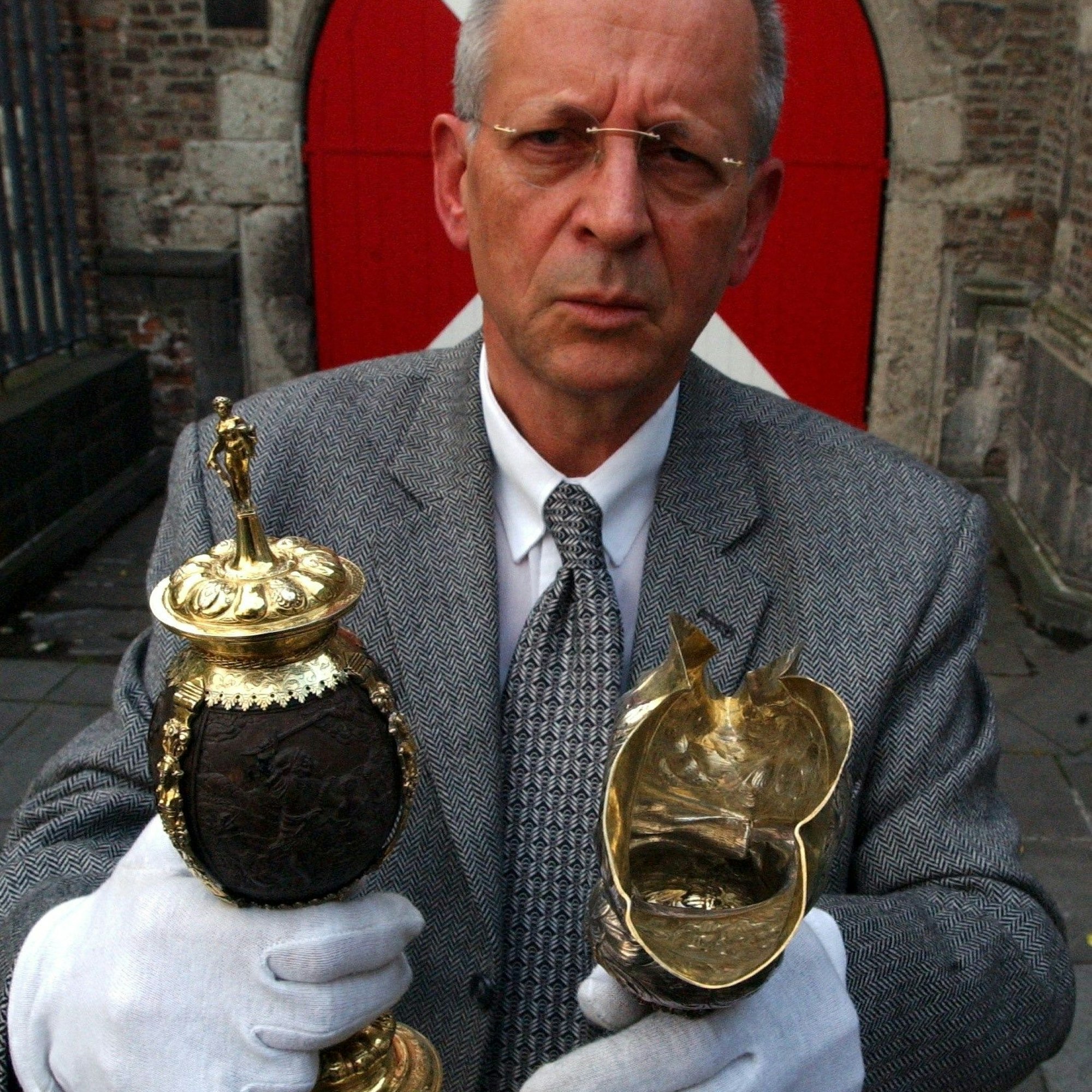 Der damalige Direktor des Kölnischen Stadtmuseums, Werner Schäfke, mit dem wieder erlangten Kokosnusspokal und einem weiteren beschädigten Silberstück.