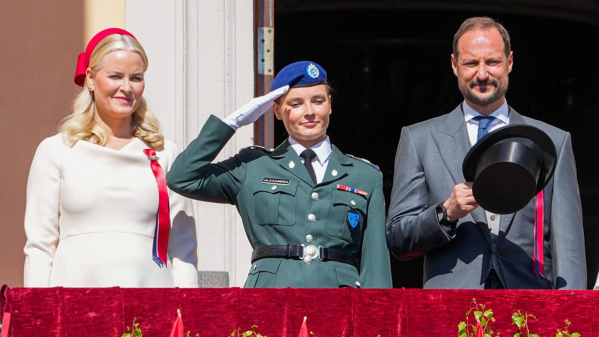 Kronprinzessin Mette-Marit (l), Kronprinz Haakon (r) und Prinzessin Ingrid Alexandra begrüßen den Kinderzug vom Schlossbalkon, während der Feierlichkeiten zum norwegischen Nationalfeiertag am 17. Mai.