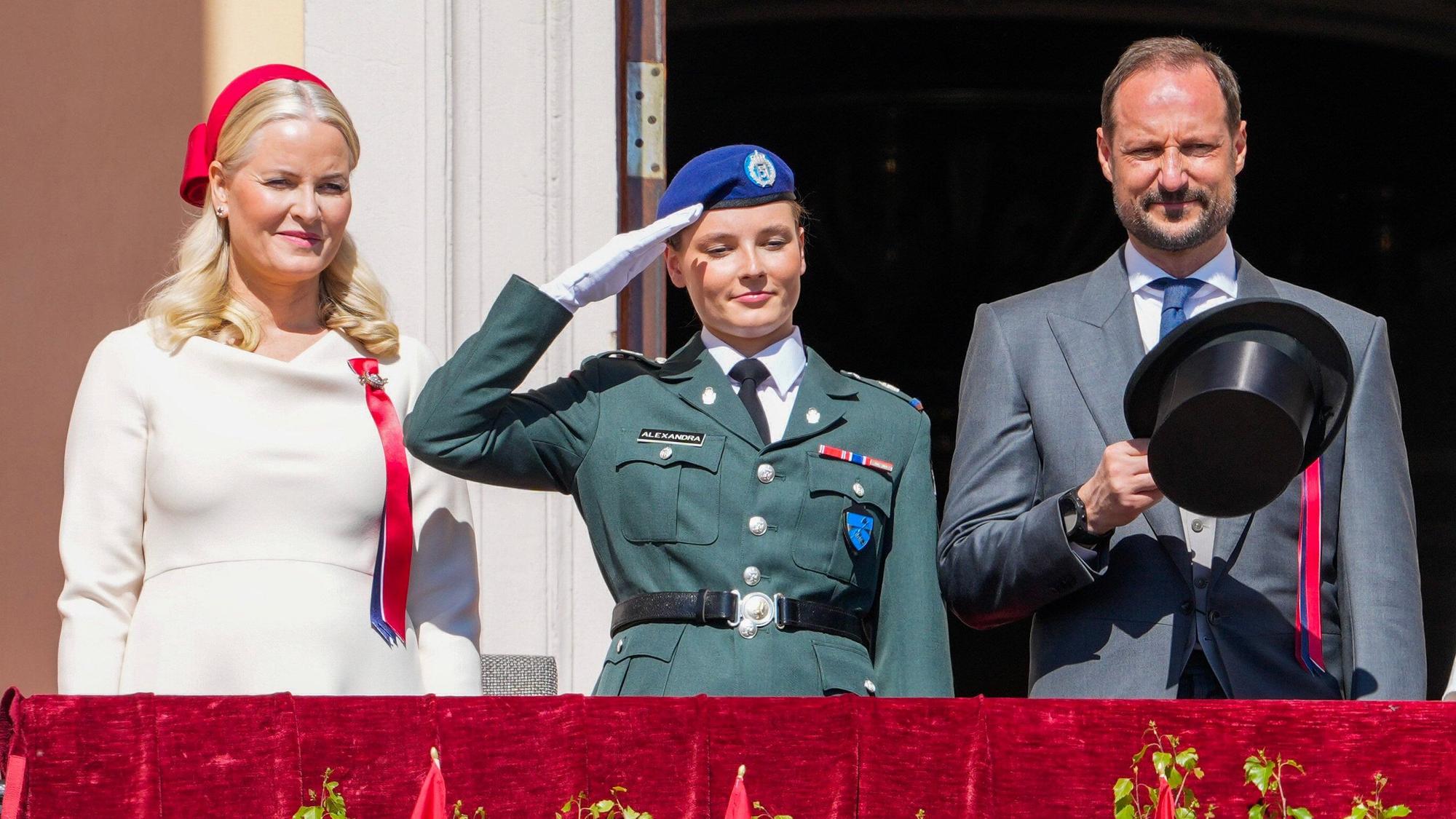 Kronprinzessin Mette-Marit (l), Kronprinz Haakon (r) und Prinzessin Ingrid Alexandra begrüßen 2024 den Kinderzug vom Schlossbalkon.