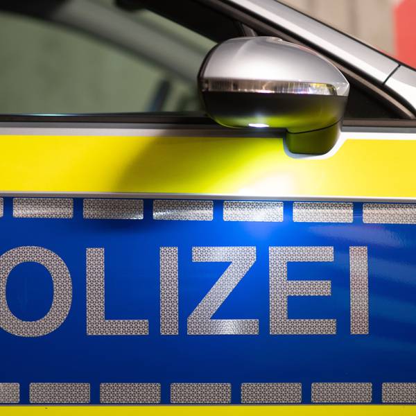 Das Wort Polizei ist auf der Tür eines Polizeiautos zu lesen.