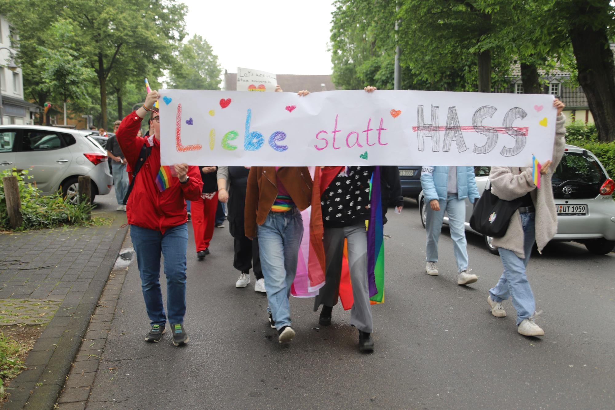 Schüler tragen ein Transparent mit der Aufschrift „Liebe statt Hass“ durch Hennefer Straßen.