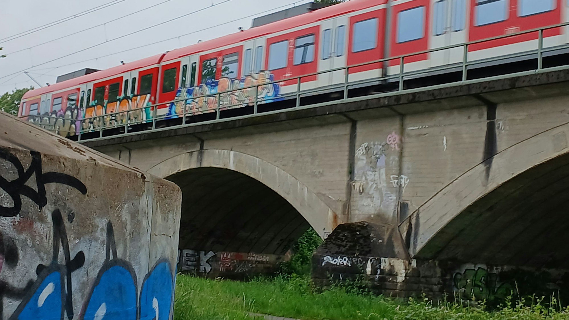 Graffiti, Brücke und S-Bahn bei Buisdorf.