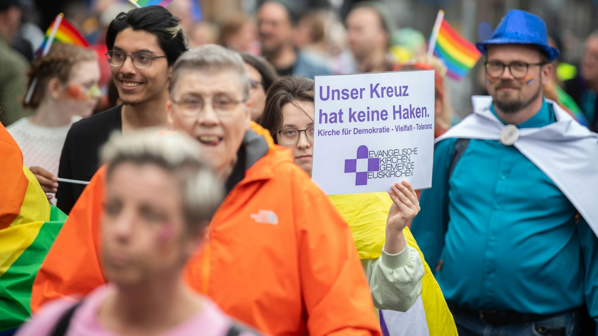 Das Bild zeigt einige Teilnehmer. Auf einem Plakat ist zu lesen: Unser Kreuz hat kein Haken. Gestaltet ist es von der evangelischen Kirche in Euskirchen.