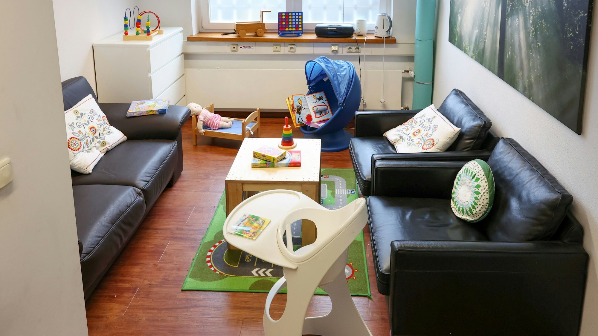 In einem Langzeitbesuchsraum der JVA stehen Sofas und ein Kinderstuhl und es liegen Spielsachen herum.