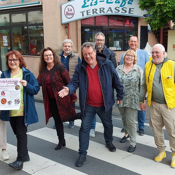 Zahlreiche Männer und Frauen stehen auf einem Zebrastreifen in Mechernich. Sie machen Werbung für die Veranstaltung Rock am Rathaus, die am 25. Mai stattfindet.