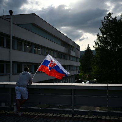 Ein Mann steht mit der slowakischen Flagge am F. D. Roosevelt Universitätskrankenhaus in Banska Bystrica, wo Robert Fico auf der Intensivstation liegt.
