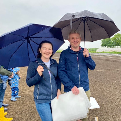 Zu sehen sind Agnieszka und Stefan Lupuliev, die Regenschirme in der Hand halten.
