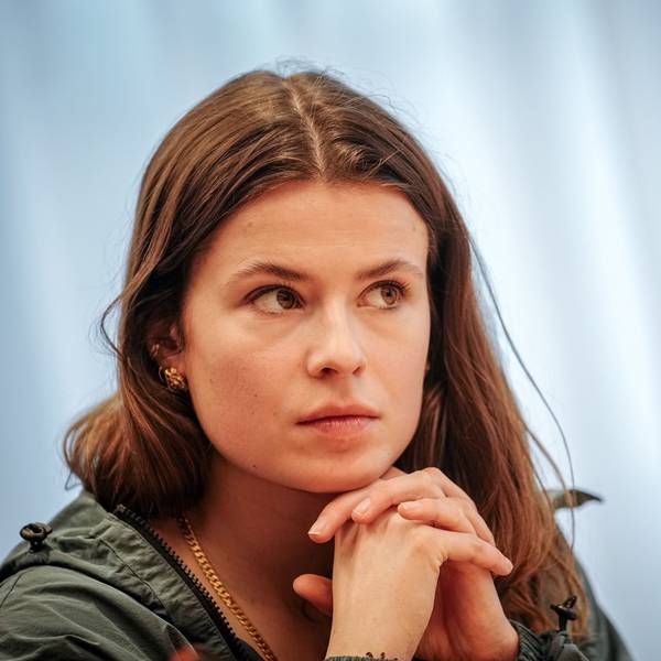 Luisa Neubauer faltet die Hände unter ihrem Kinn.