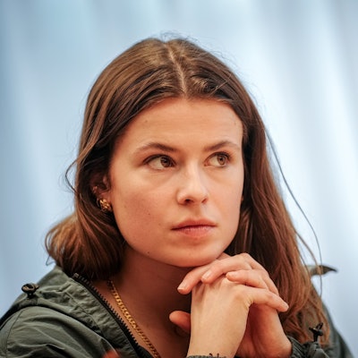 Luisa Neubauer faltet die Hände unter ihrem Kinn.