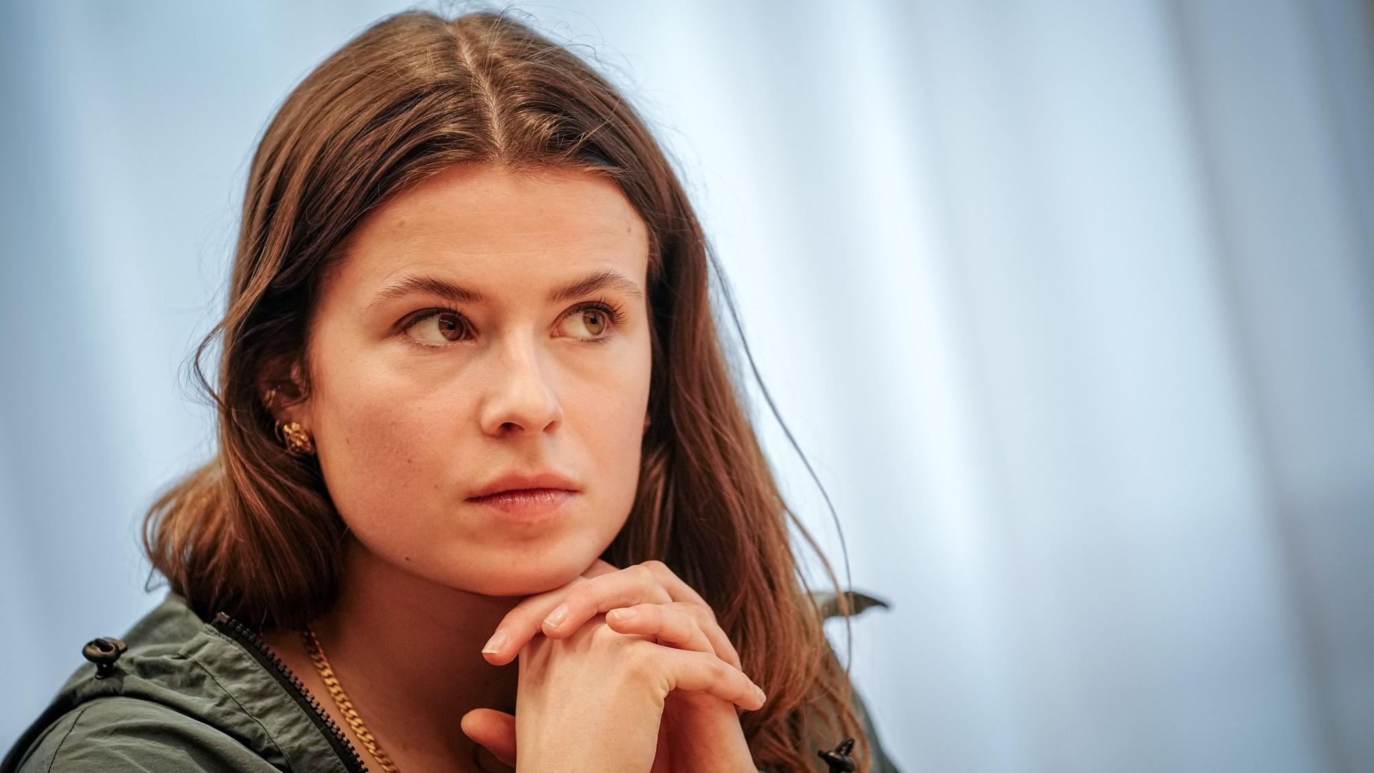 Luisa Neubauer faltet die Hände unter ihrem Kinn.