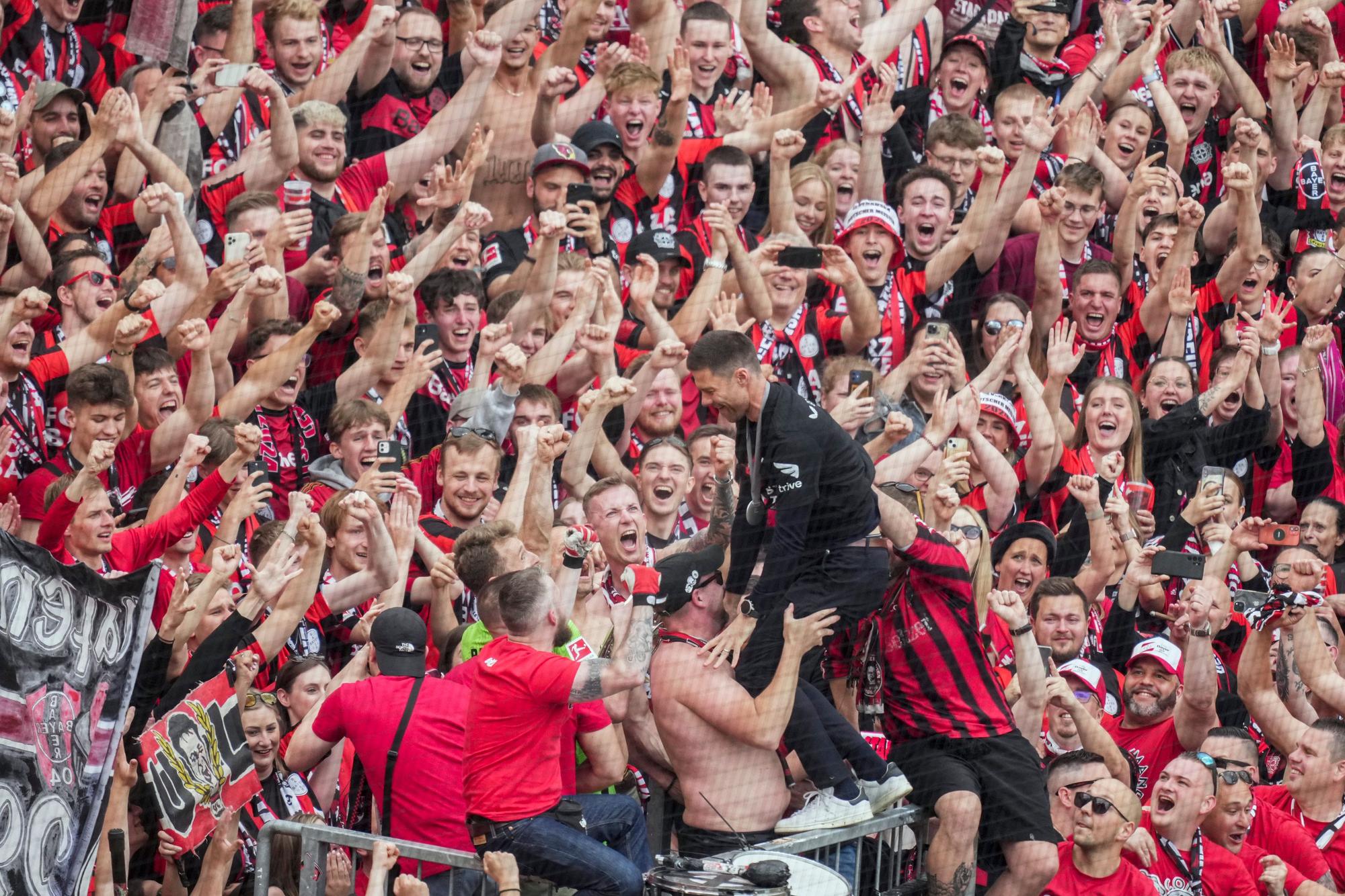Leverkusen's head coach Xabi Alonso celebrates with fans as his team won the German Bundesliga, after the German Bundesliga soccer match between Bayer Leverkusen and FC Augsburg at the BayArena in Leverkusen, Germany, Saturday, May 18, 2024. Bayer Leverkusen have won the Bundesliga title for the first time. It is the first team in Bundesliga history, that won the championship unbeaten for the whole season. (AP Photo/Michael Probst)
