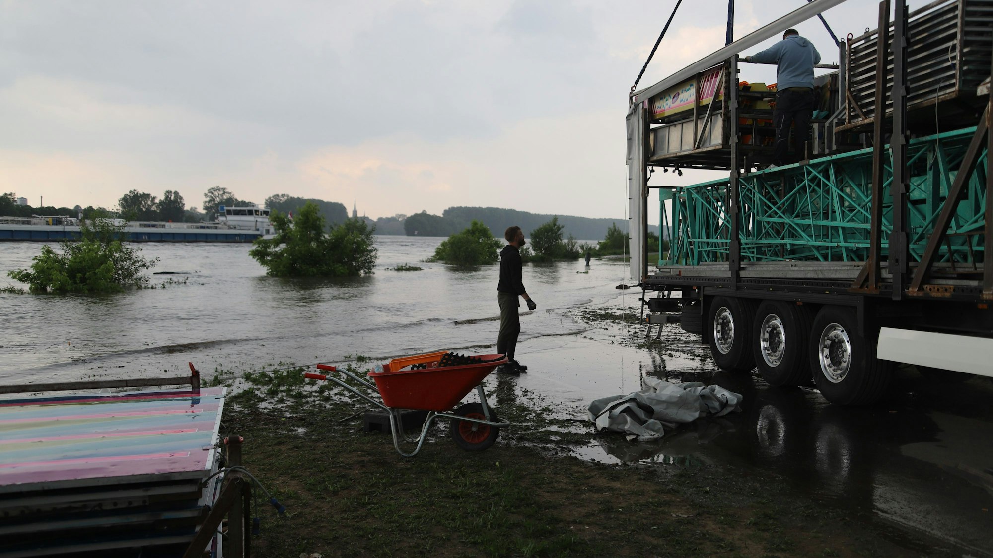 Am Samstag wurden beim Strandfest in Mondorf die direkt am Rhein aufgebauten Fahrgeschäfte wegen des Hochwassers wieder abgebaut. Teilweise mussten die Schausteller schon im Wasser arbeiten.
