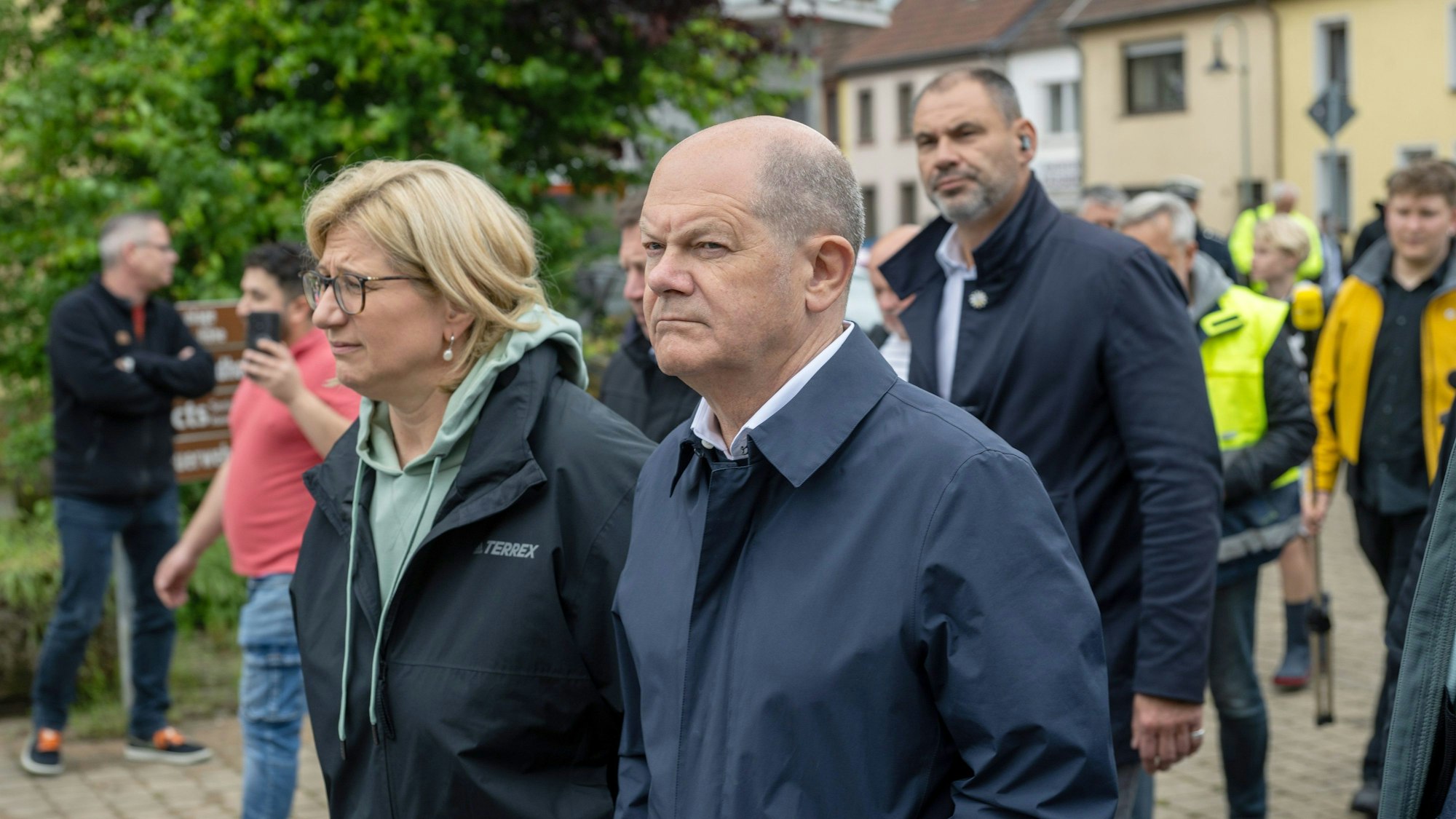 Bundeskanzler Olaf Scholz (rechts, SPD) und die saarländische Ministerpräsidentin Anke Rehlinger (links, SPD) besuchen den vom Hochwasser betroffenen Ort Kleinblittersdorf und werden von Anwohnern begleitet.