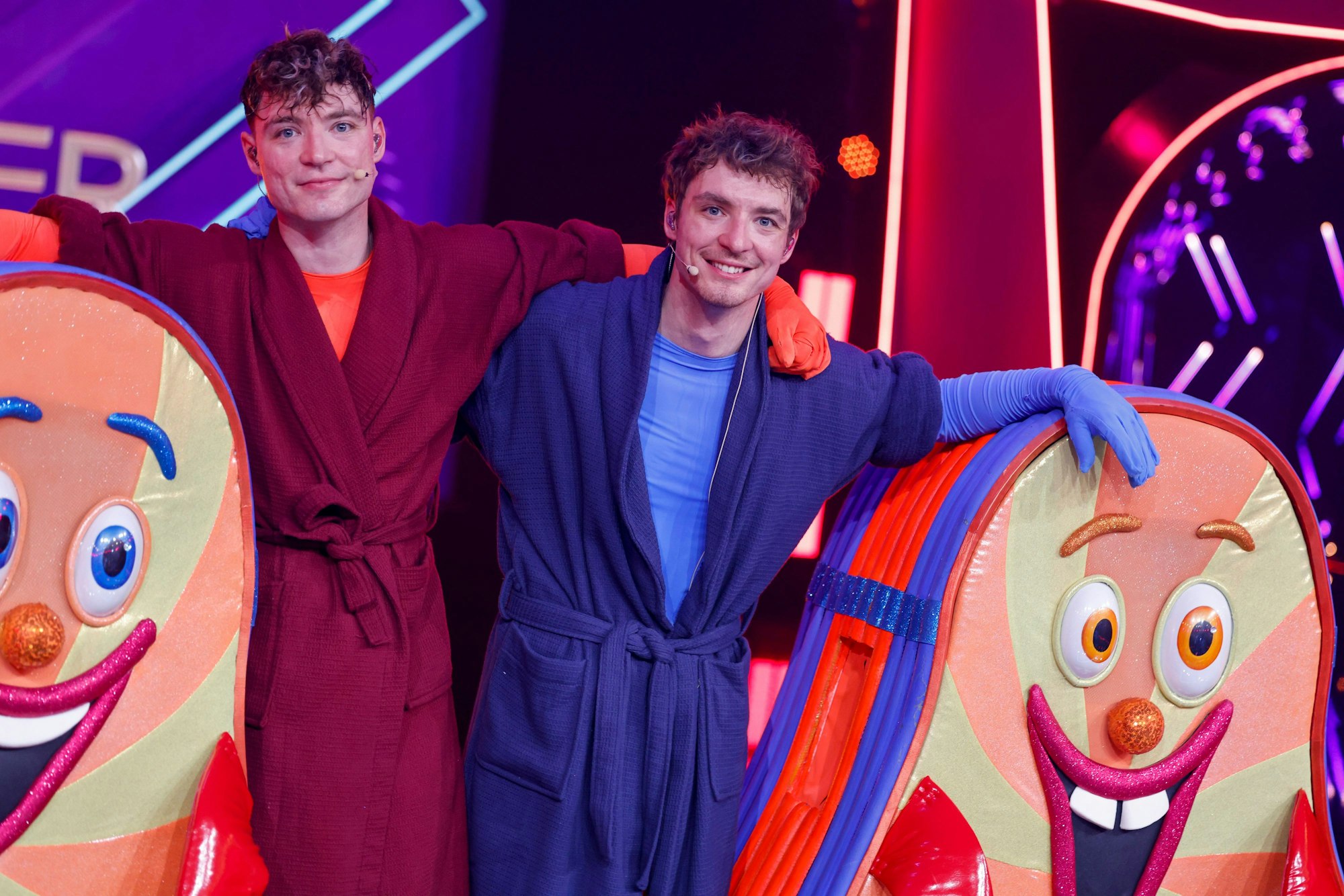 18.05.2024, Nordrhein-Westfalen, Köln: Die Zwillingsbrüder Roman und Heiko Lochmann (l-r) stehen als enttarnte Figur «Flip Flop» im Finale der Prosieben-Show «The Masked Singer» auf der Bühne. Foto: Thomas Banneyer/dpa +++ dpa-Bildfunk +++