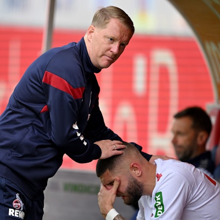 Kölns Julian Chabot (r) sitzt nach dem Spiel auf der Wechselbank und weint nach dem Abstieg seiner Mannschaft. Er wird dabei von Kölns Trainer Timo Schultz getröstet.