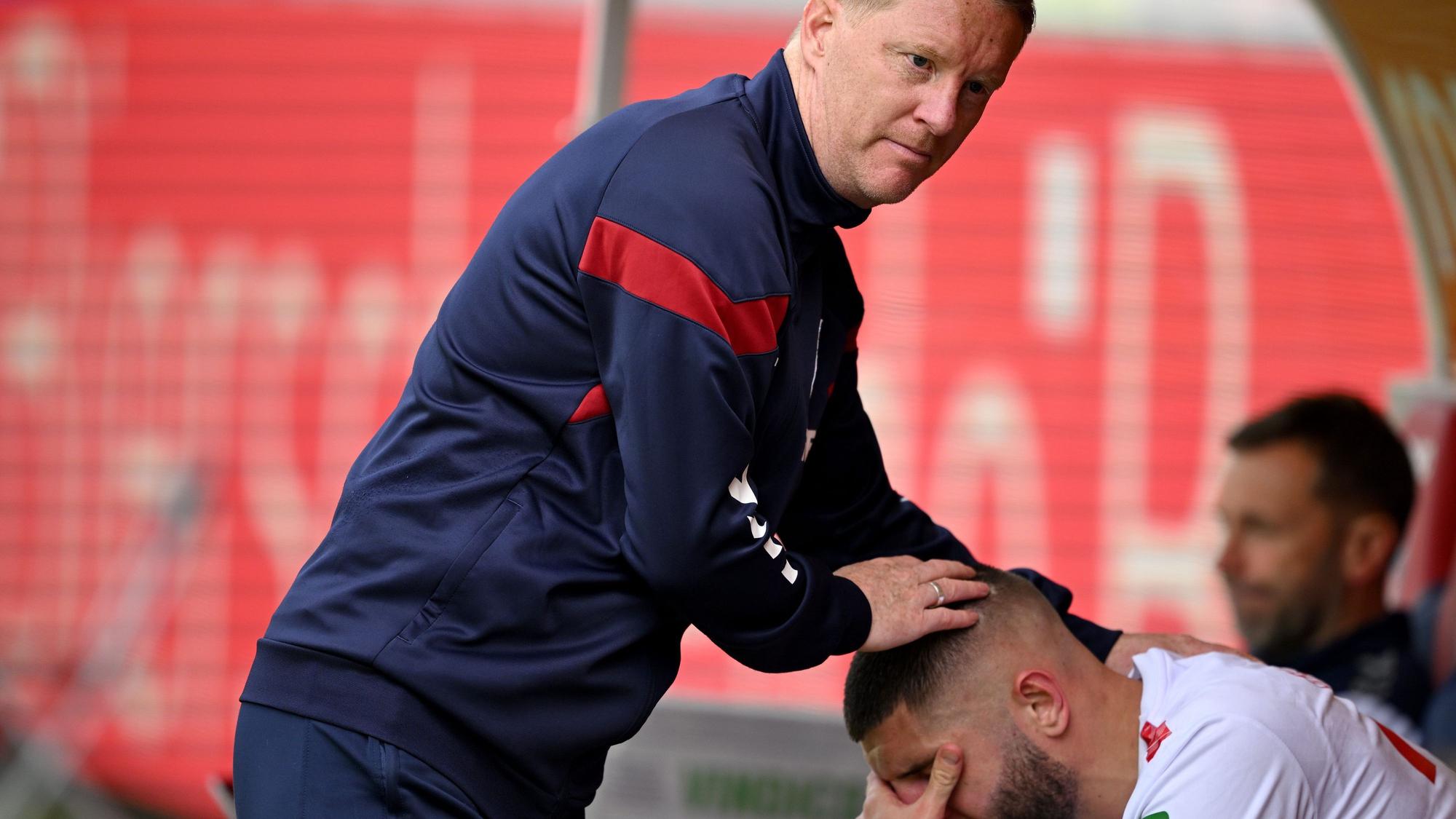 Kölns Julian Chabot (r) sitzt nach dem Spiel auf der Wechselbank und weint nach dem Abstieg seiner Mannschaft. Er wird dabei von Kölns Trainer Timo Schultz getröstet.