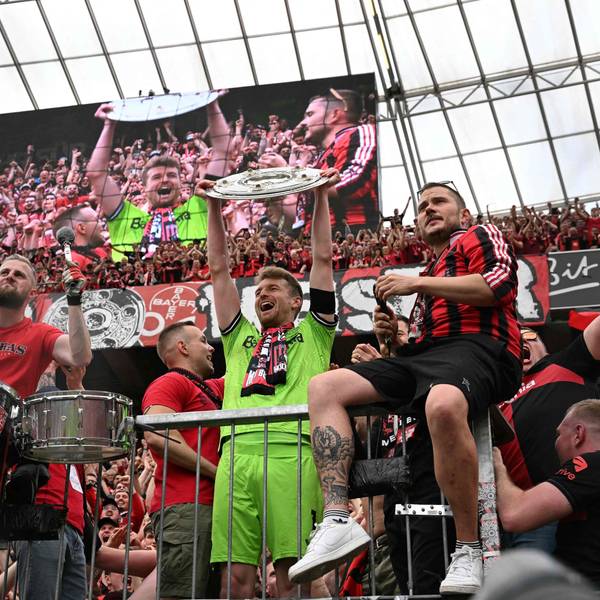 Bayer Leverkusen's Finnish goalkeeper #01 Lukas Hradecky celebrates with the Bundesliga trophy amongst the fans after the German first division Bundesliga football match between Bayer 04 Leverkusen and FC Augsburg in Leverkusen, western Germany on May 18, 2024. (Photo by INA FASSBENDER / AFP) / DFL REGULATIONS PROHIBIT ANY USE OF PHOTOGRAPHS AS IMAGE SEQUENCES AND/OR QUASI-VIDEO